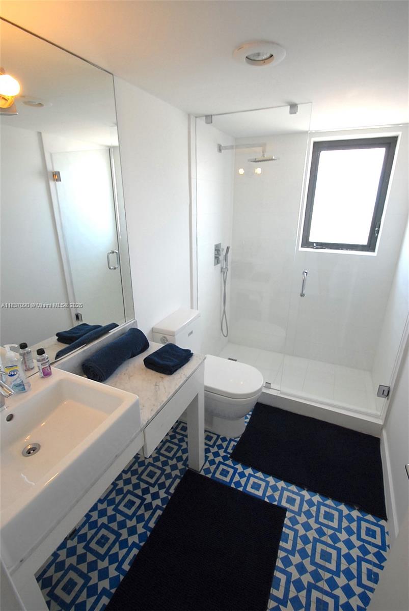 1800 Collins Avenue, Unit 18F Miami Beach, FL 33139 - Photo 15 of 22 a bathroom with a sink and a mirror