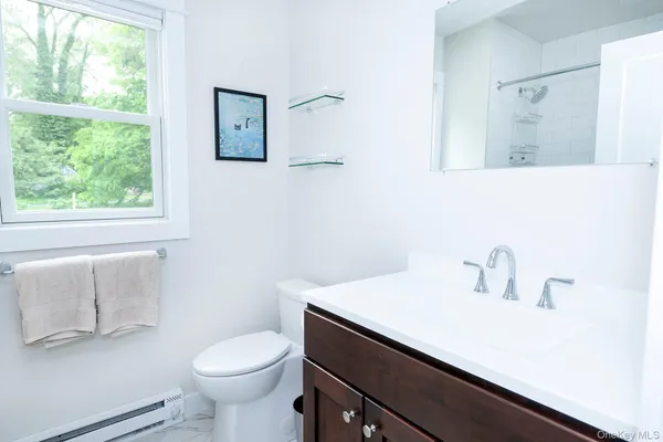 a bathroom with a sink toilet and window