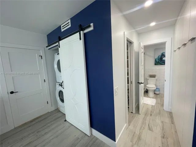 a bathroom with a walk in closet and wooden floor