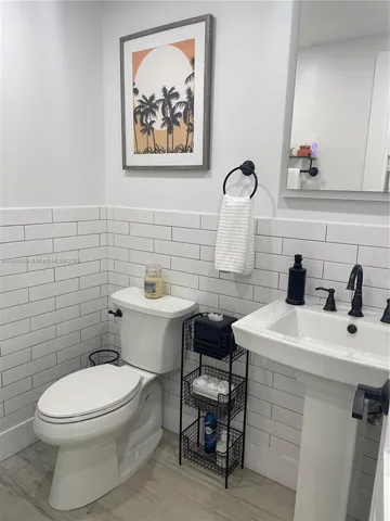 a bathroom with a toilet a sink and mirror