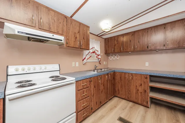 a view of empty room with wooden floor and cabinet