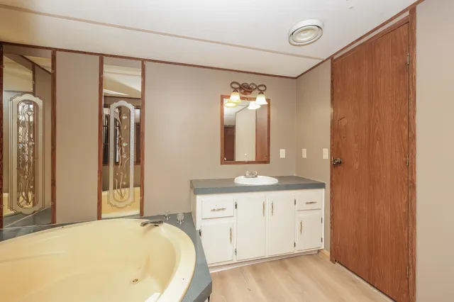 a bathroom with a tub sink and mirror