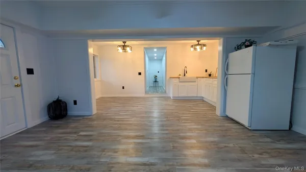 a view of a refrigerator in an empty room and a window