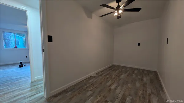 a view of a room with wooden floor and fan