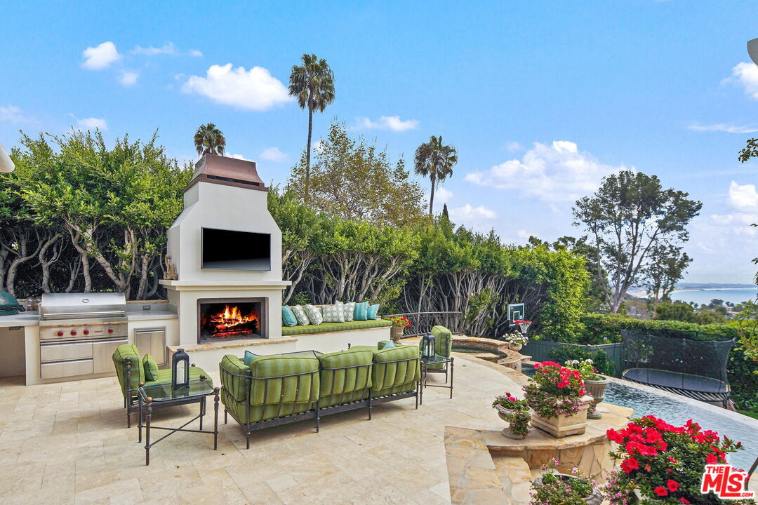 541 Paseo Miramar Pacific Palisades, CA 90272 - Photo 34 of 50 a living room with furniture a flat screen tv and a fireplace