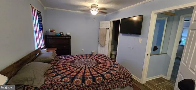 a bedroom with a bed and a flat tv screen on dresser