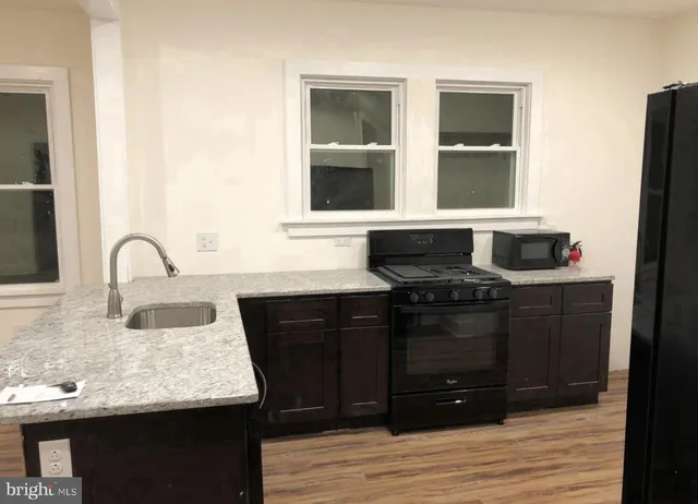 a kitchen with granite countertop a sink and a stove