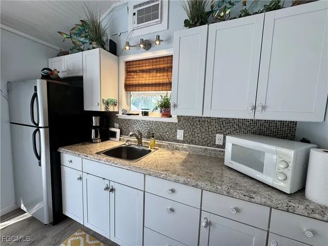 a kitchen with stainless steel appliances granite countertop a sink and a refrigerator