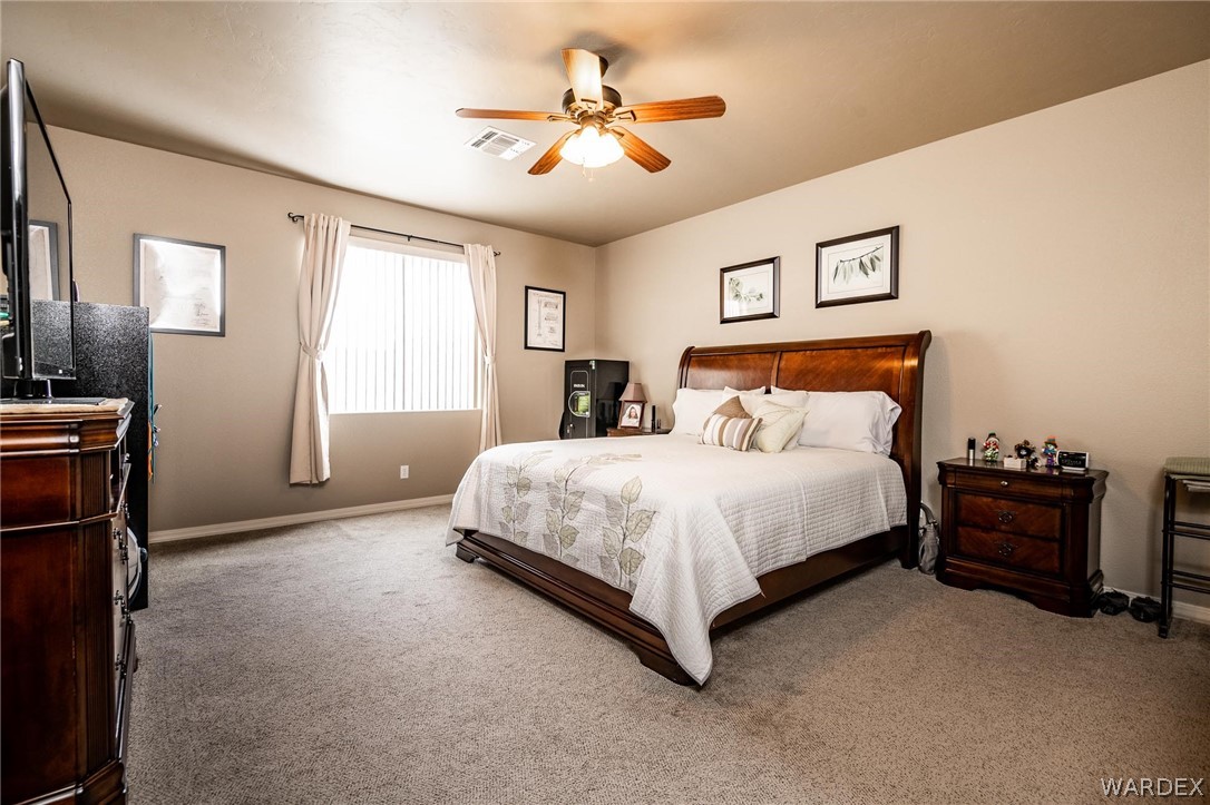 4870 North Old W Road Kingman, AZ 86401 - Photo 20 of 41 a spacious bedroom with a bed and a chandelier