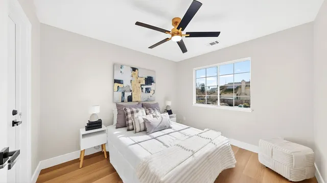 a bedroom with a bed a chair and the dresser