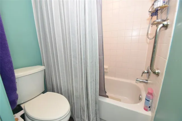 a white toilet sitting next to a bath tub