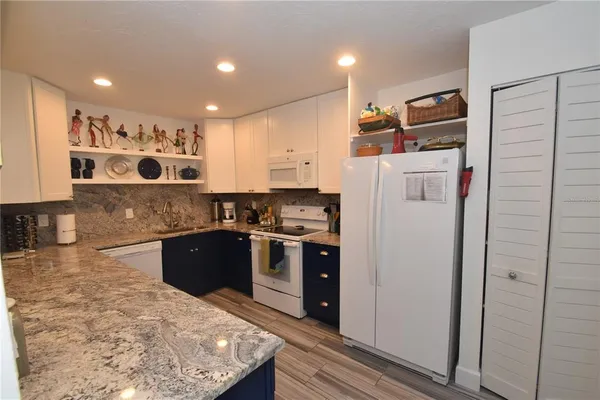 a kitchen with stainless steel appliances granite countertop a refrigerator and a stove