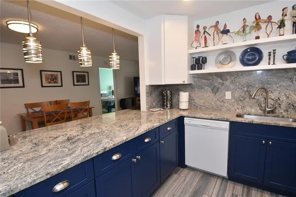 a kitchen with kitchen island granite countertop a sink and cabinets