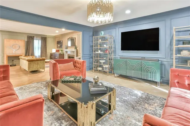 a living room with furniture a flat screen tv and kitchen view