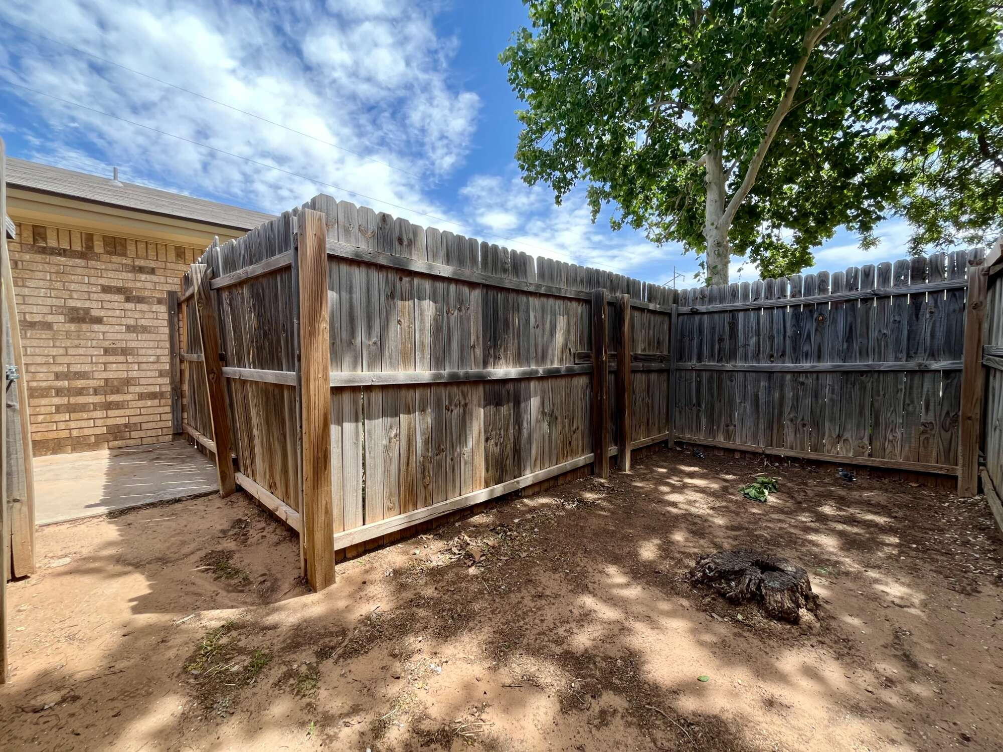 2308 74th Street, Unit B3 Lubbock, TX 79423 - Photo 17 of 18 a view of a backyard with wooden fence and large trees