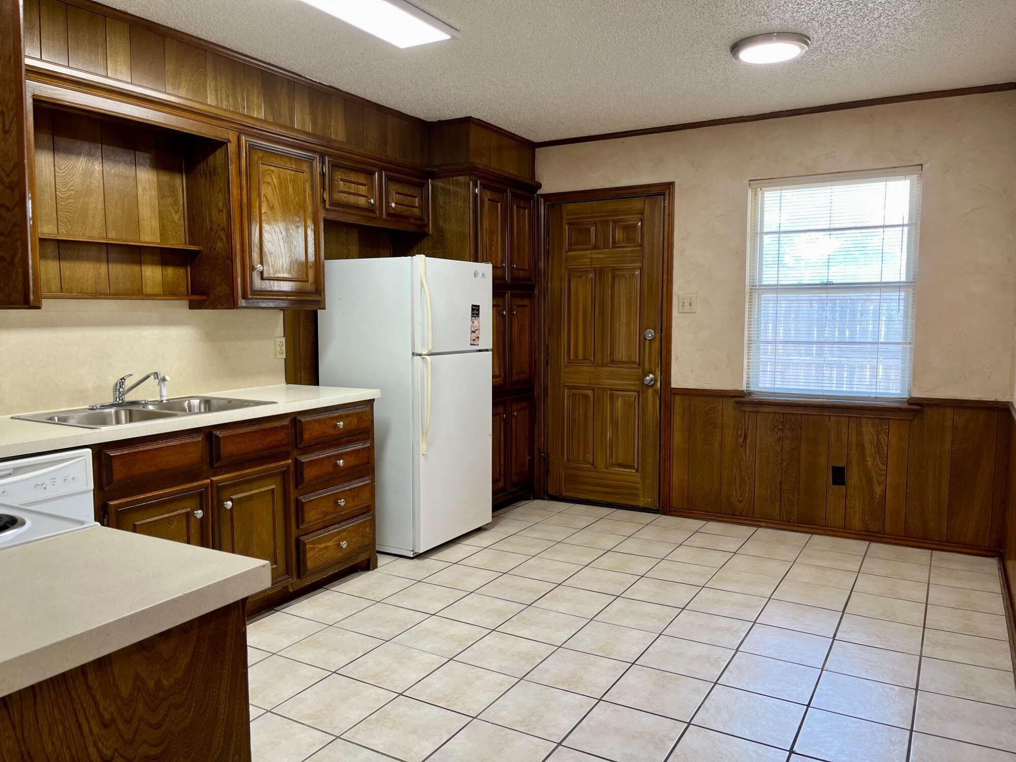 2308 74th Street, Unit B3 Lubbock, TX 79423 - Photo 6 of 18 a kitchen with a refrigerator and cabinets