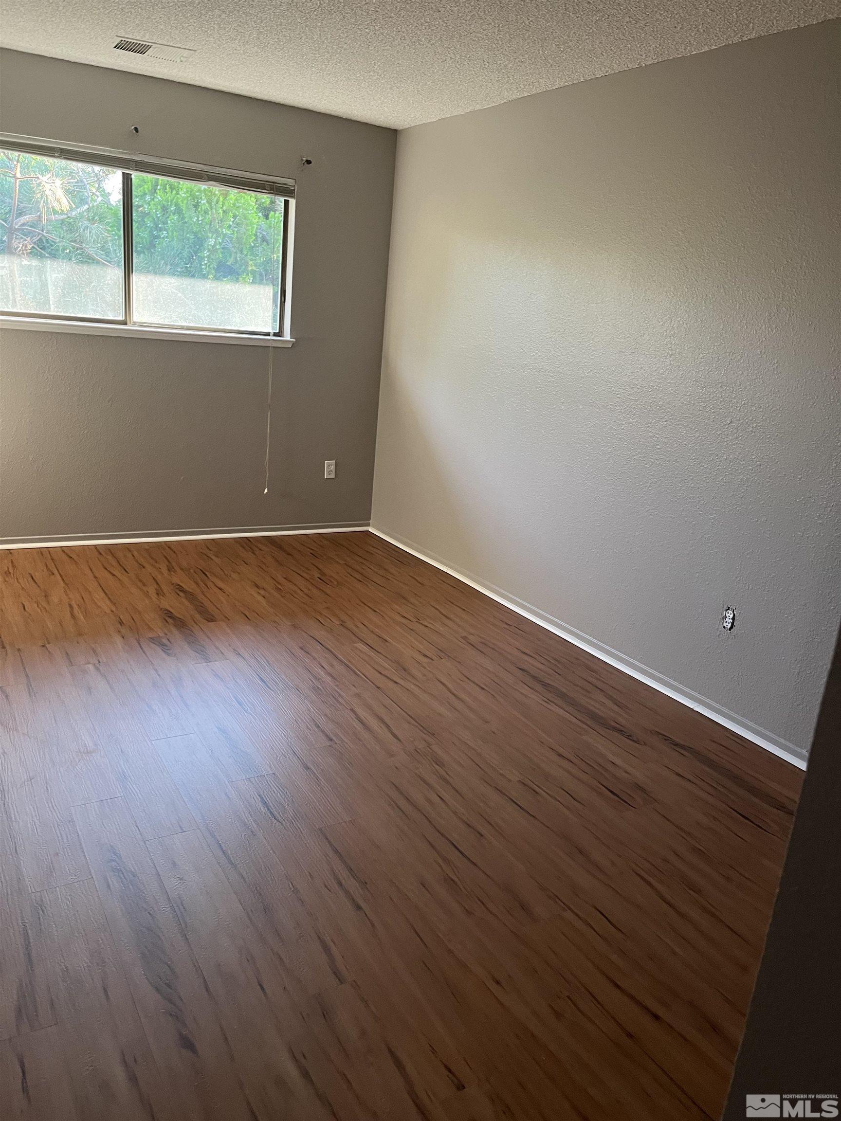 2197 Kietzke Lane, Unit E Reno, NV 89502 - Photo 5 of 7 a view of an empty room with wooden floor and a window