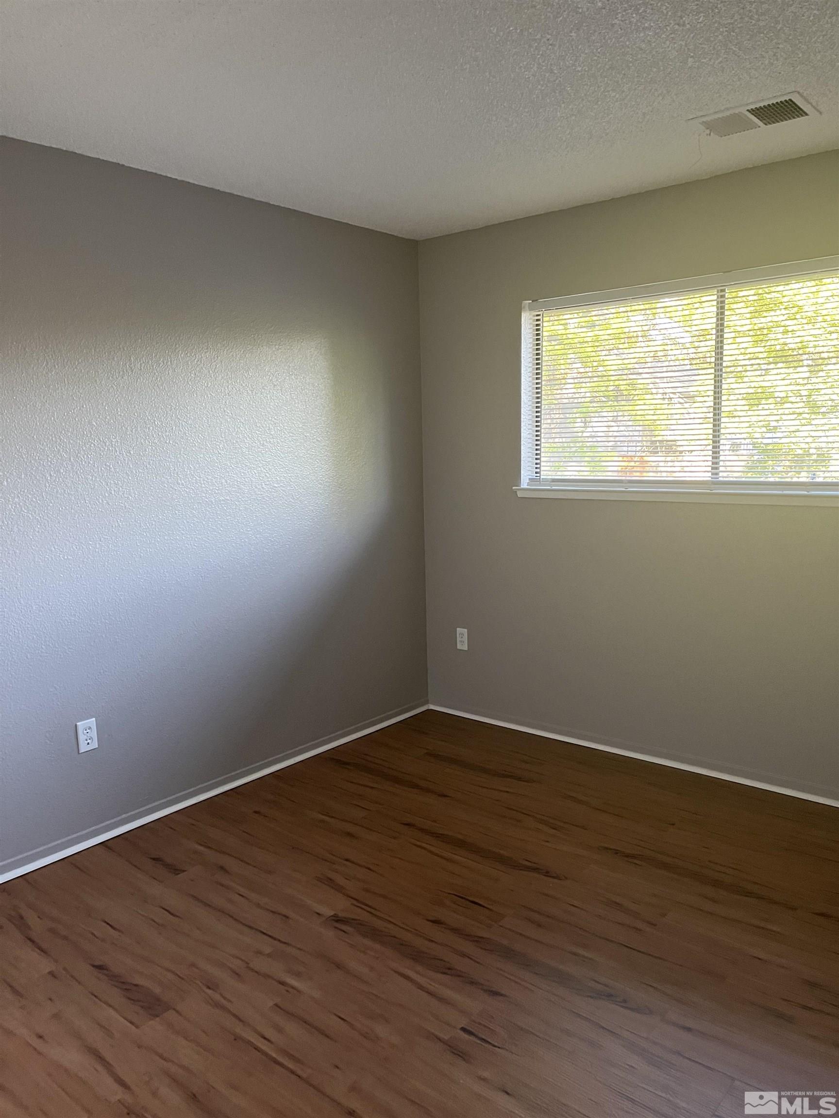 2197 Kietzke Lane, Unit E Reno, NV 89502 - Photo 7 of 7 a view of an empty room with wooden floor and a window