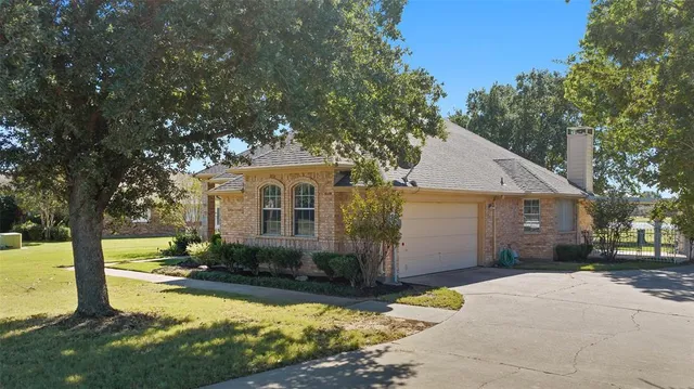 a front view of house with yard and trees in the background