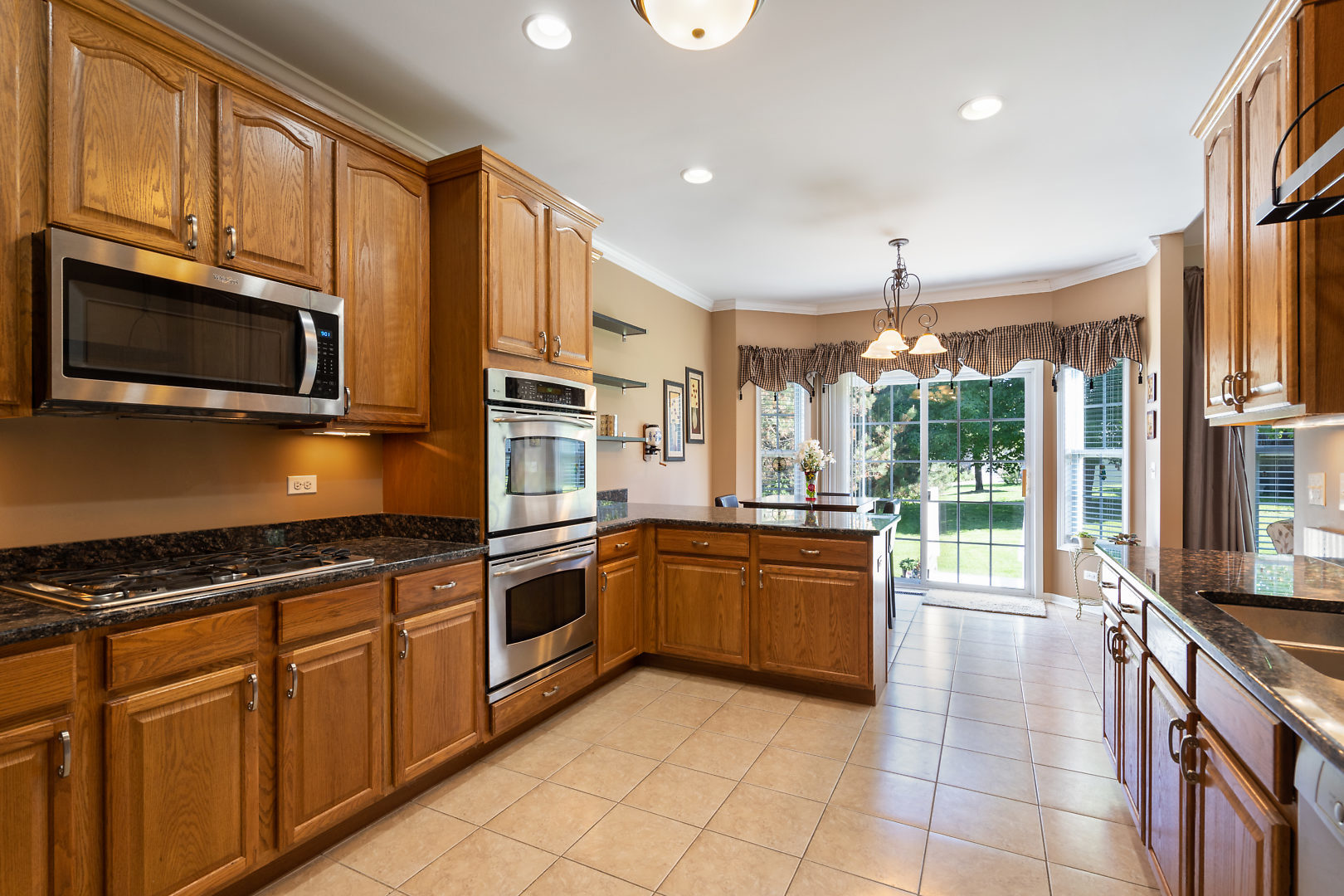 14 Winthrop New Road Sugar Grove, IL 60554 - Photo 9 of 25 a kitchen with stainless steel appliances granite countertop a stove top oven microwave and cabinets