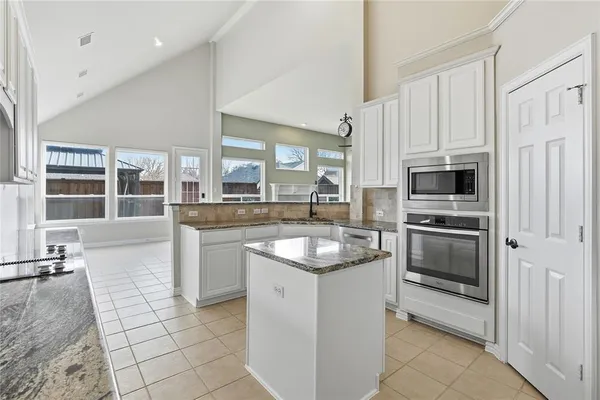 a kitchen with stainless steel appliances granite countertop a stove microwave and cabinets