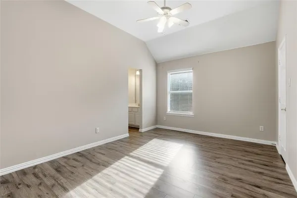 an empty room with wooden floor and a ceiling fan