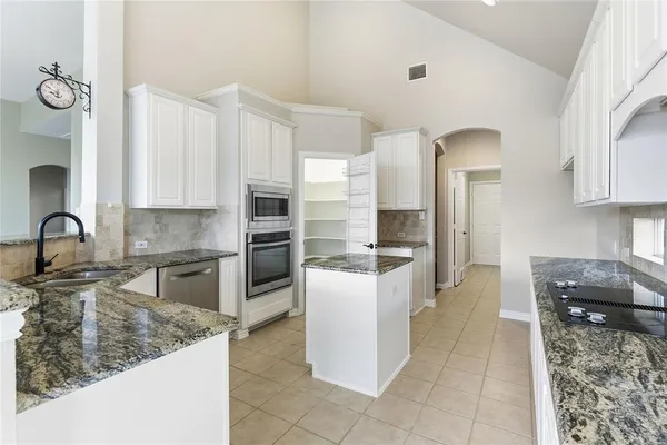 a kitchen with stainless steel appliances granite countertop a stove and a sink