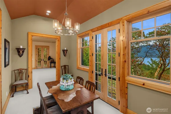 a view of a dining room with furniture a chandelier and window