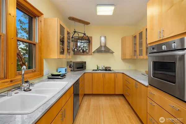 a kitchen with stainless steel appliances granite countertop a sink and a stove