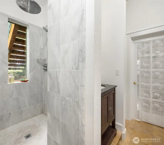 a bathroom with a granite countertop shower and a sink