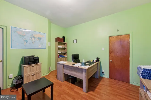 a view of a workspace with furniture and wooden floor