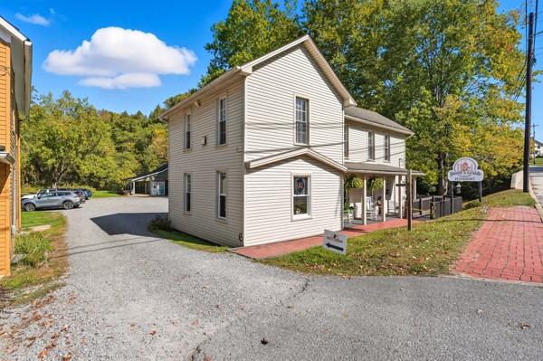 300 Main Street Volant, PA 16156 - Photo 2 of 31 a view of a white house with a yard and table and chairs under an umbrella