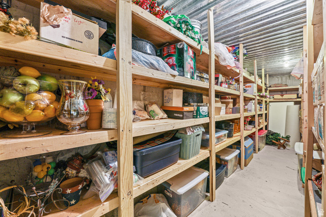 31 Village Square Road Centerville, UT 84014 - Photo 22 of 29 Utility room with extensive built-in wooden shelving, a concrete floor, and corrugated metal ceiling