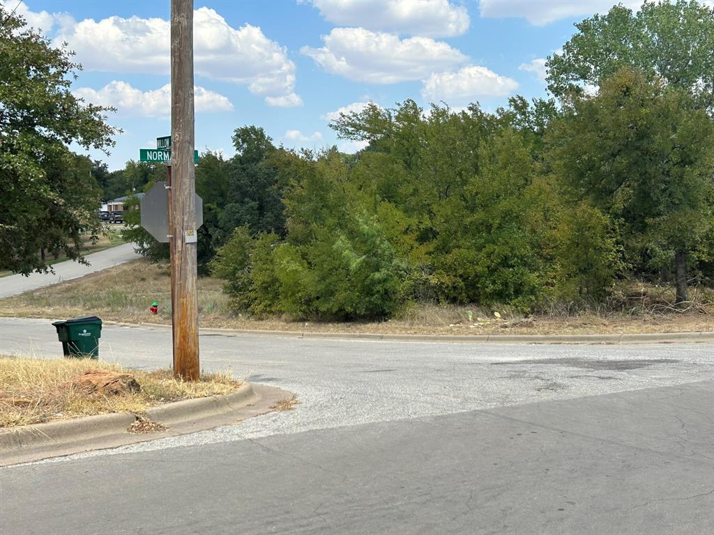 1414 Normandy Drive Graham, TX 76450 - Photo 4 of 5 a street sign on a sidewalk next to a road