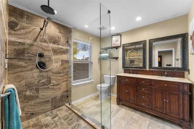 a bathroom with a granite countertop sink a mirror and shower