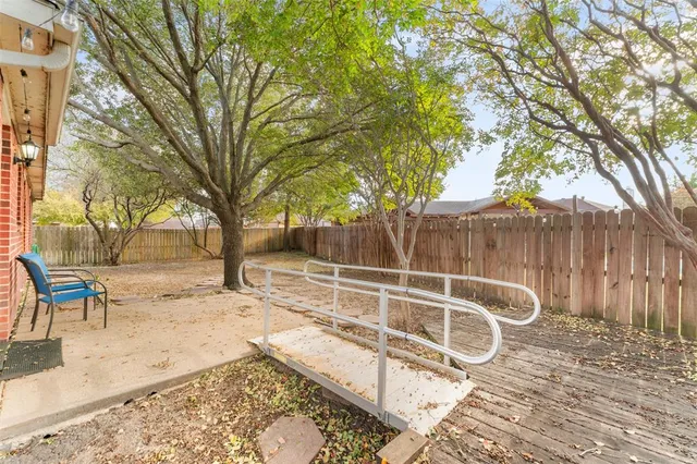 a view of backyard with small cabin and wooden fence