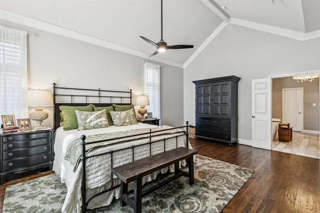 a bedroom with a bed a dresser and wooden floor
