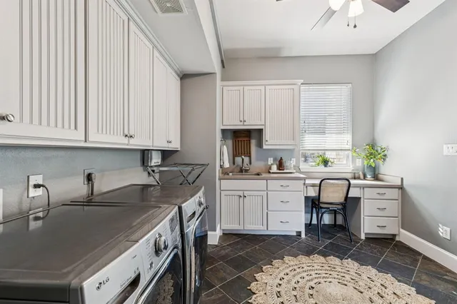 a kitchen with white cabinets and sink