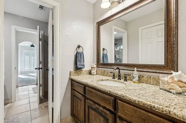 a bathroom with a granite countertop sink and a mirror