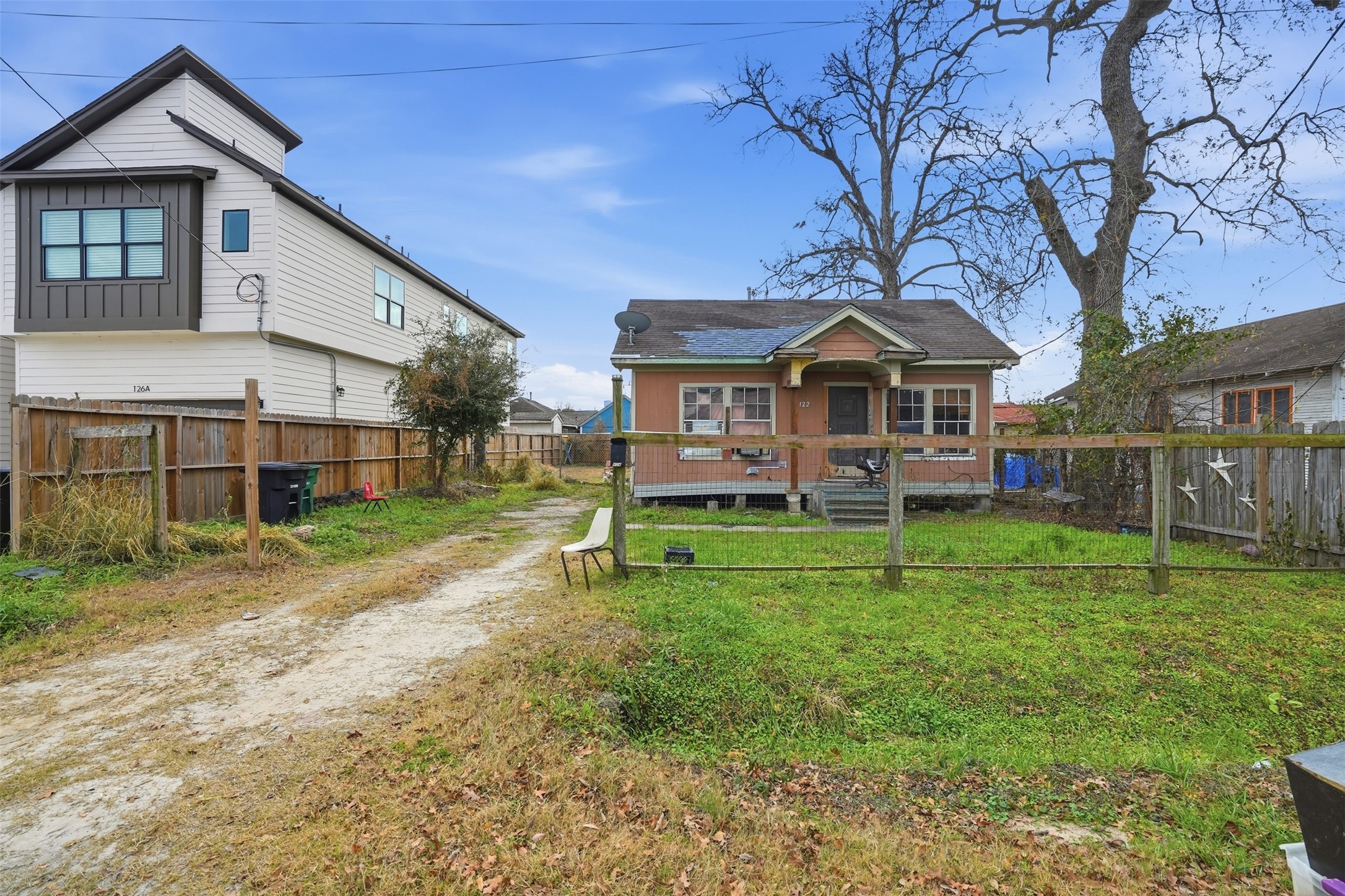 a view of a house with a big yard plants and large trees