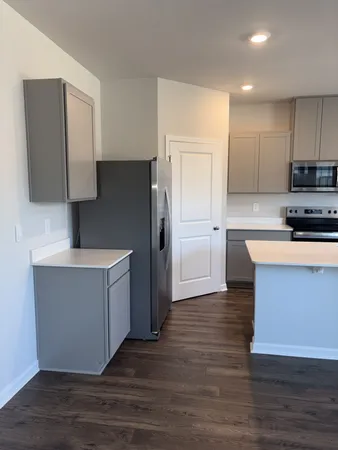 a kitchen with stainless steel appliances white cabinets a sink a stove a refrigerator and island