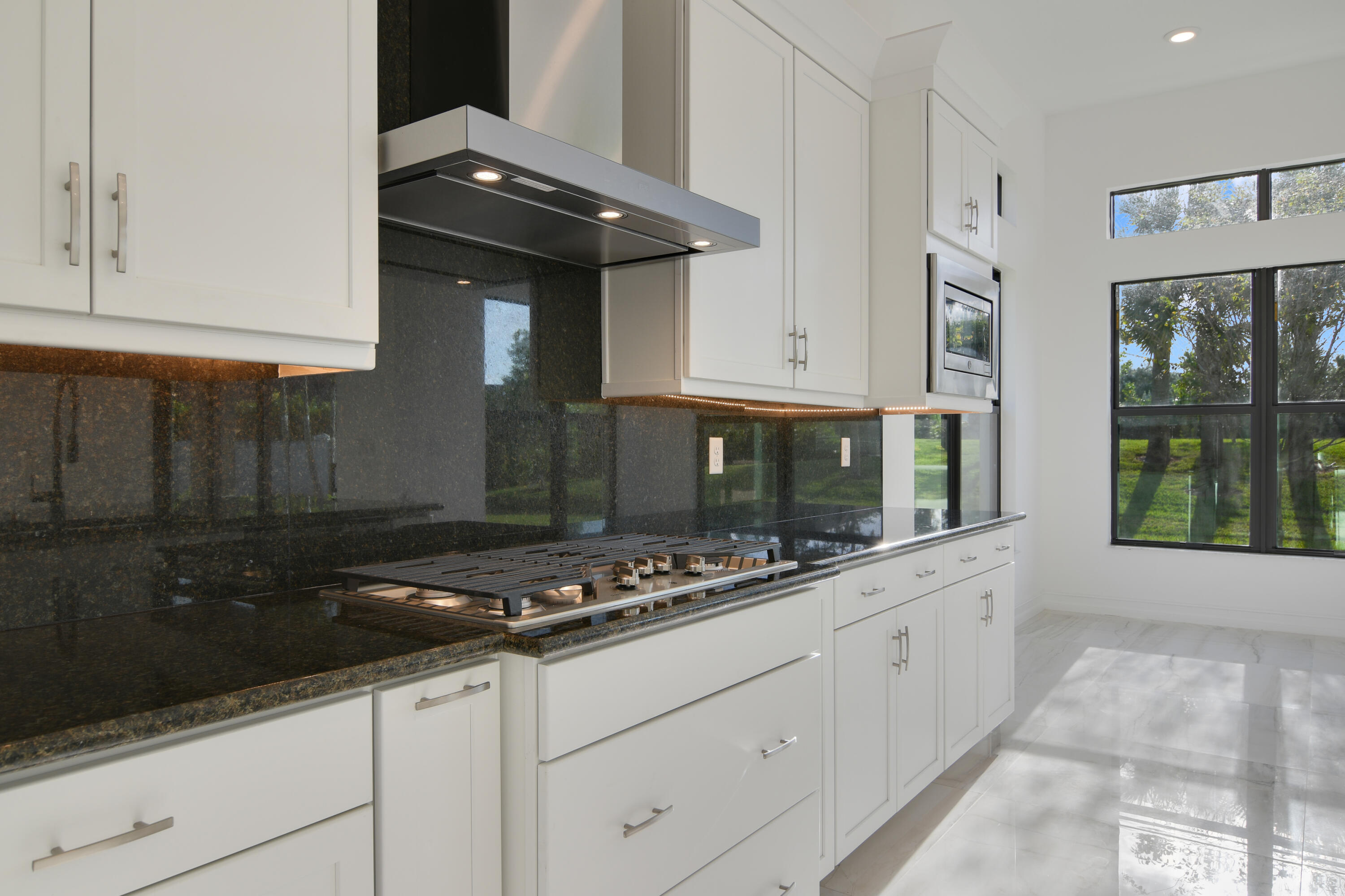 8827 Leon Circle, Unit 286 Parkland, FL 33076 - Photo 13 of 34 a kitchen with granite countertop white cabinets and window