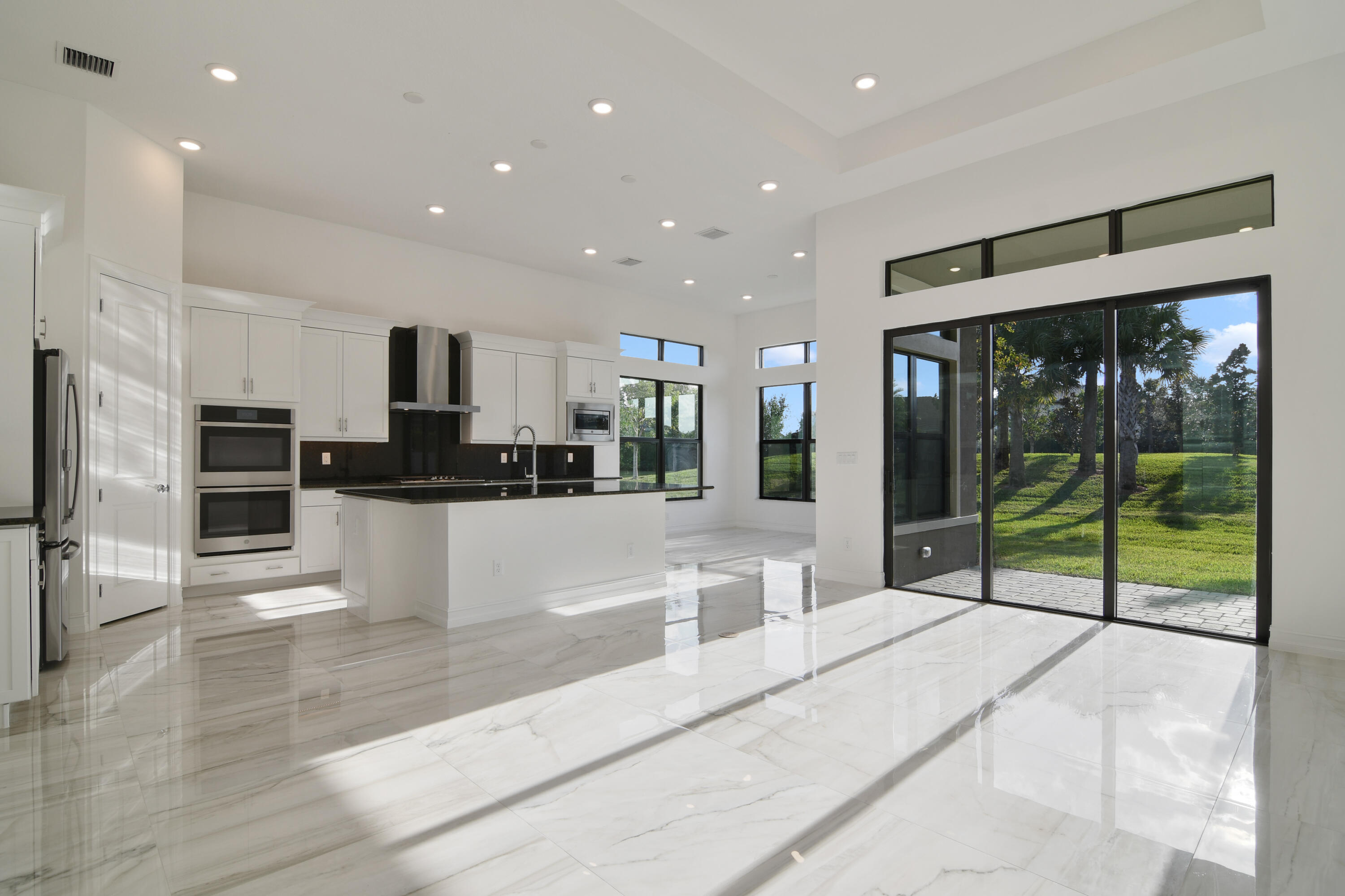 8827 Leon Circle, Unit 286 Parkland, FL 33076 - Photo 16 of 34 a large kitchen with stainless steel appliances kitchen island granite countertop a refrigerator and a sink
