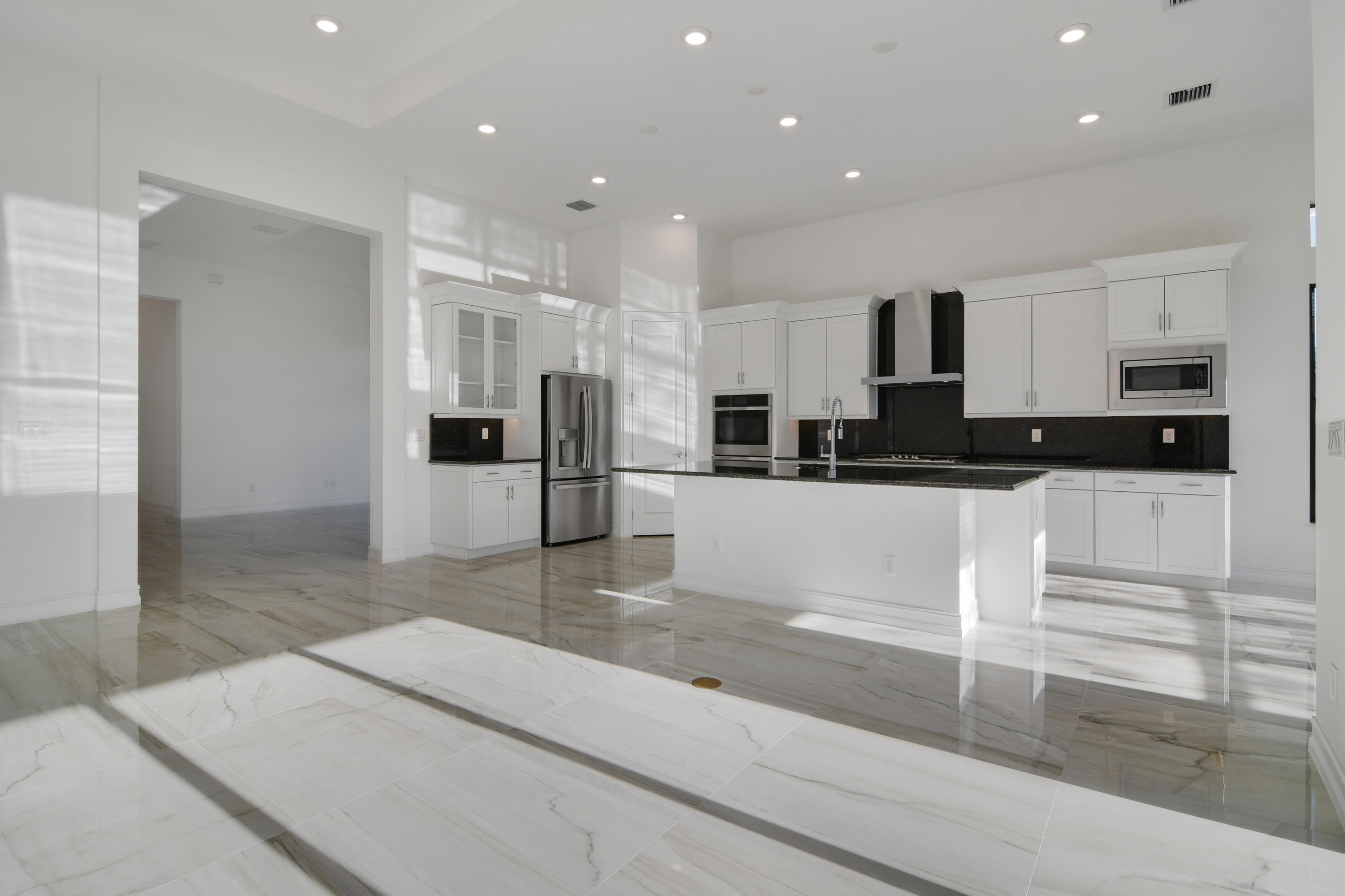 8827 Leon Circle, Unit 286 Parkland, FL 33076 - Photo 17 of 34 a large kitchen with stainless steel appliances kitchen island granite countertop a refrigerator and a sink
