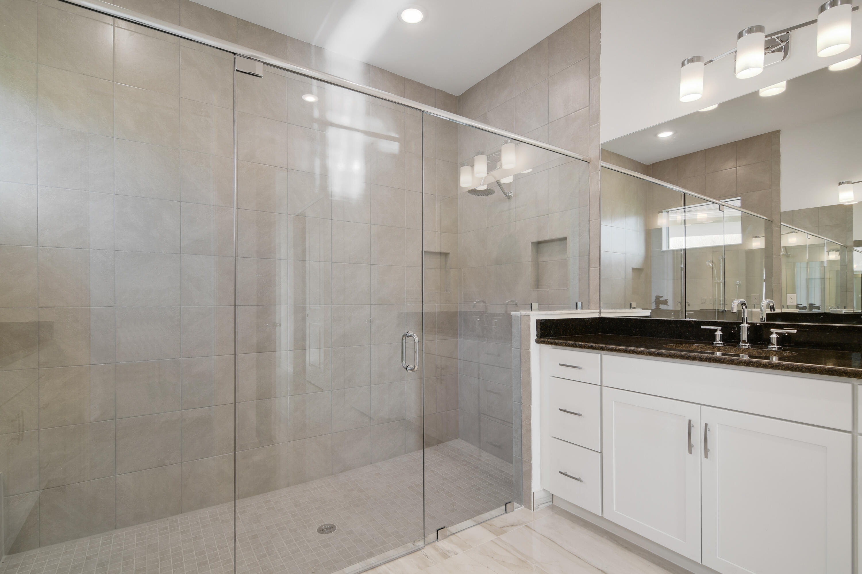 8827 Leon Circle, Unit 286 Parkland, FL 33076 - Photo 26 of 34 a bathroom with a granite countertop sink a shower and a mirror