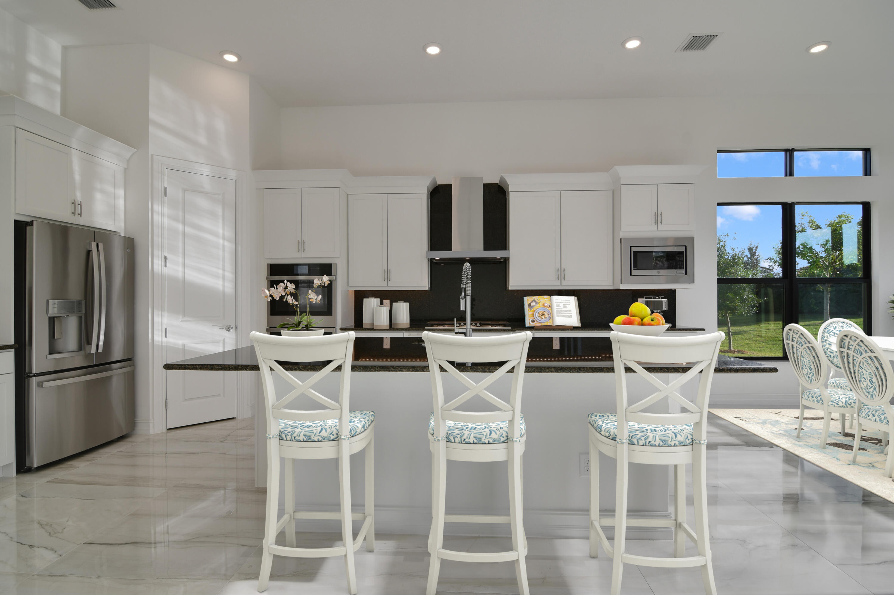 8827 Leon Circle, Unit 286 Parkland, FL 33076 - Photo 3 of 34 a kitchen with stainless steel appliances kitchen island granite countertop a table and chairs