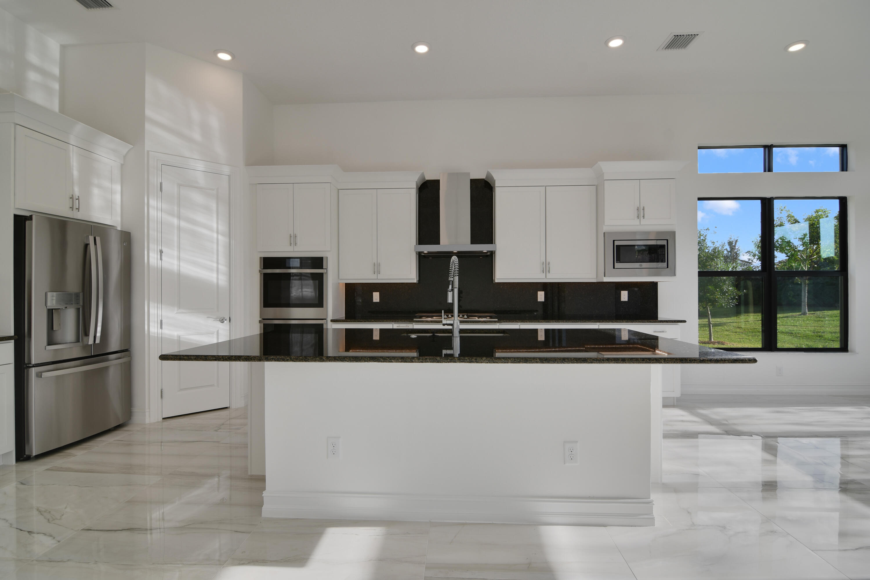 8827 Leon Circle, Unit 286 Parkland, FL 33076 - Photo 9 of 34 a kitchen with stainless steel appliances kitchen island granite countertop a refrigerator and a sink