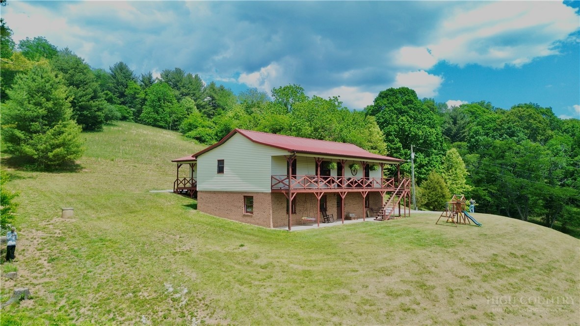 1315 Irwin Grocery Road Laurel Springs, NC 28644 - Photo 3 of 22 a view of a house with a big yard plants and large trees