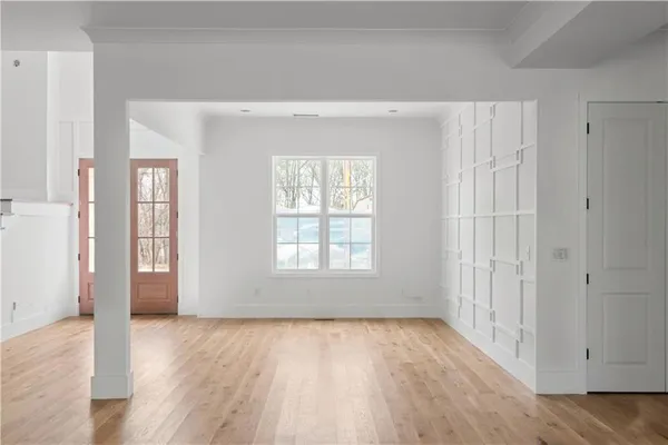 an empty room with wooden floor and windows