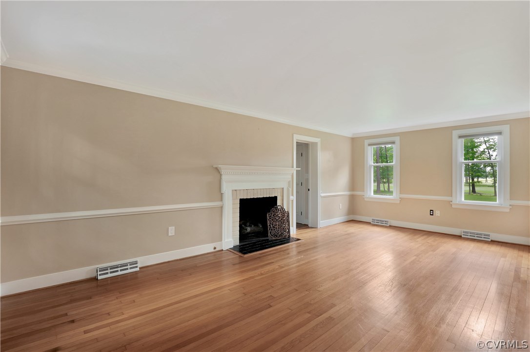 2620 Radstock Road Midlothian, VA 23113 - Photo 5 of 25 an empty room with wooden floor fireplace and windows
